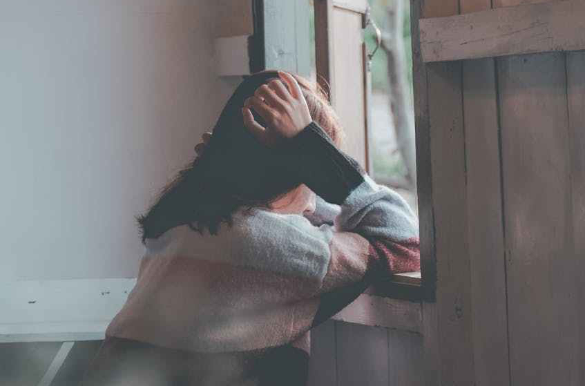 photo of a person leaning on wooden window